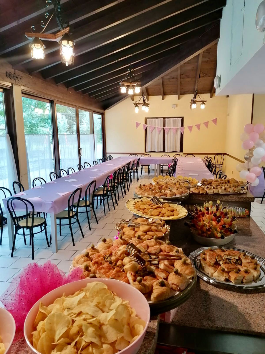 Un tavolo festosamente decorato con cibo e dolci colorati, preparati per un servizio di catering per un compleanno.